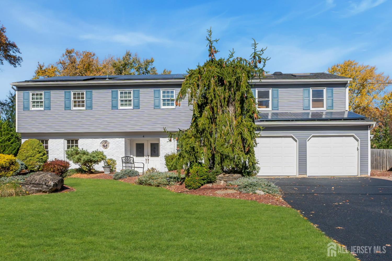 4 Canadian Woods Road Marlboro, NJ 07746 - Photo 2 of 45 a front view of a house with a garden