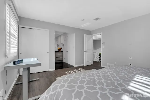 a bedroom with a sink and a mirror