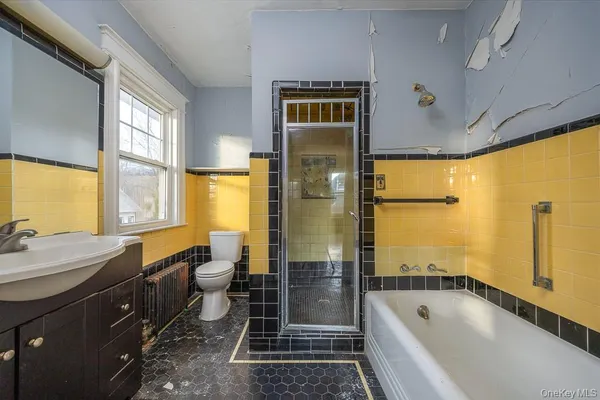 a bathroom with a granite countertop tub sink a window and a shower