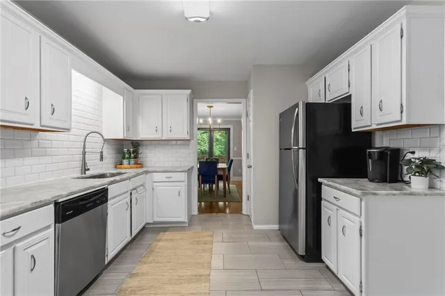 a kitchen with a refrigerator sink and white cabinets