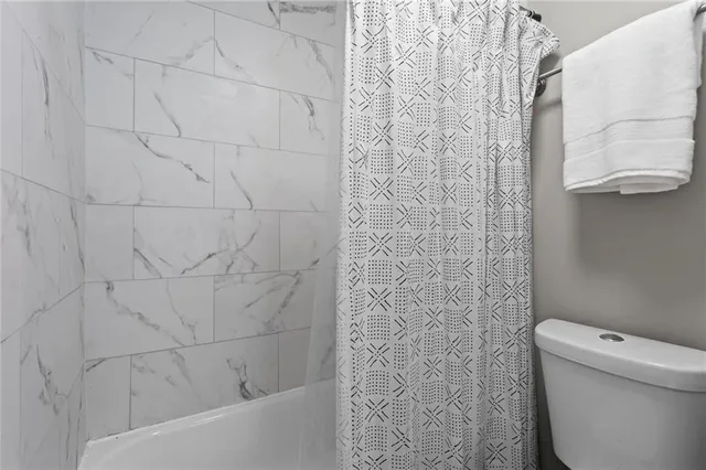 a bathroom with a toilet and a shower curtain