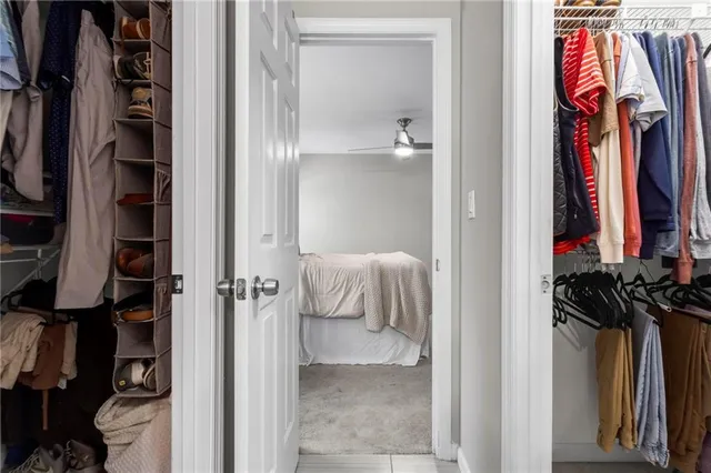 a view of walk in closet with clothes and shoes