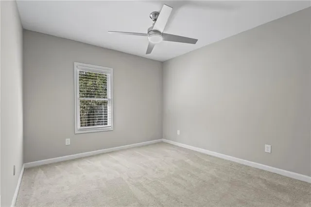 an empty room with a window and ceiling fan