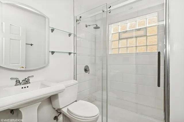 a bathroom with a sink toilet a mirror and shower
