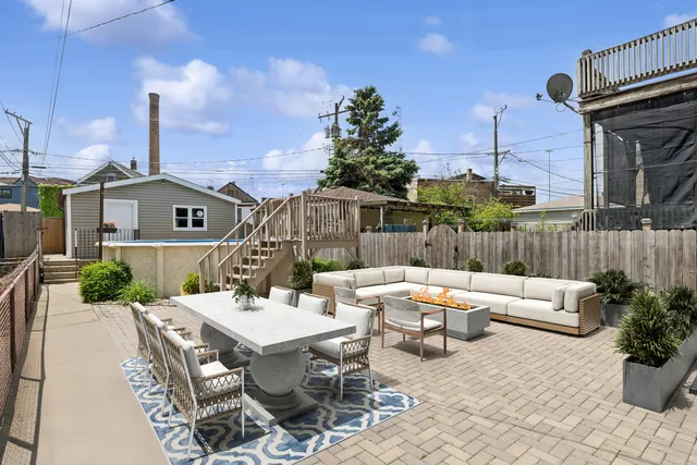 a view of a patio with couches table and chairs and potted plants