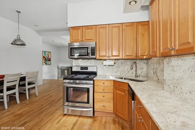 a kitchen with stainless steel appliances granite countertop a stove a sink and a microwave
