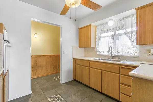 an empty room with a window and a ceiling fan