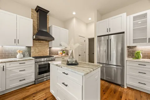 a kitchen with a stove a refrigerator and cabinets