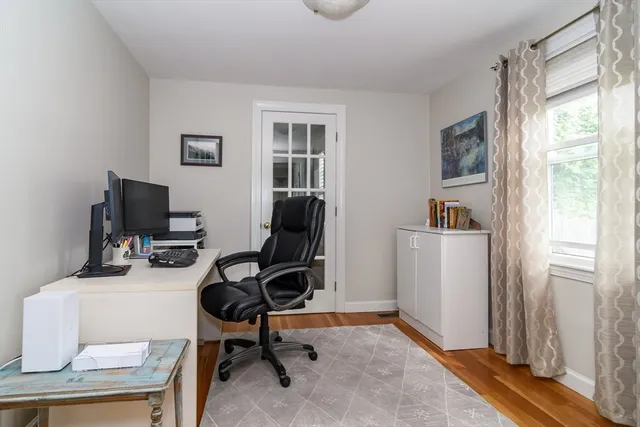 a view of a workspace with furniture and a window