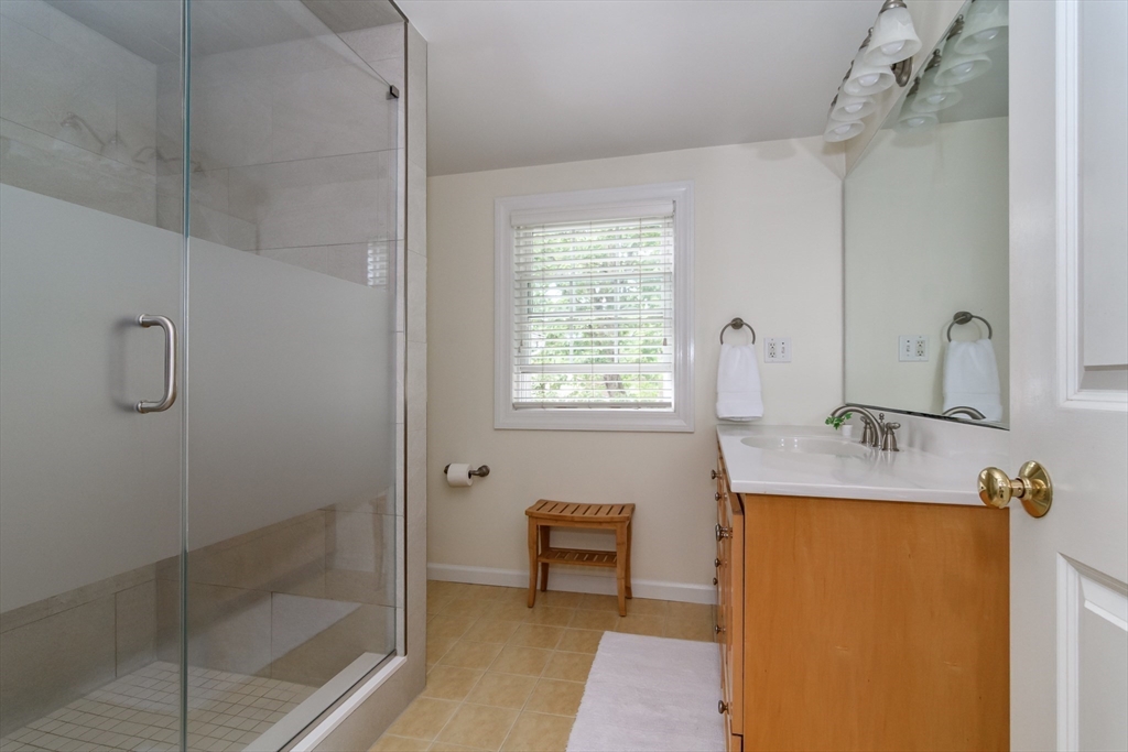 50 Felch Road Natick, MA 01760 - Photo 16 of 32 a bathroom with a granite countertop sink a mirror and shower