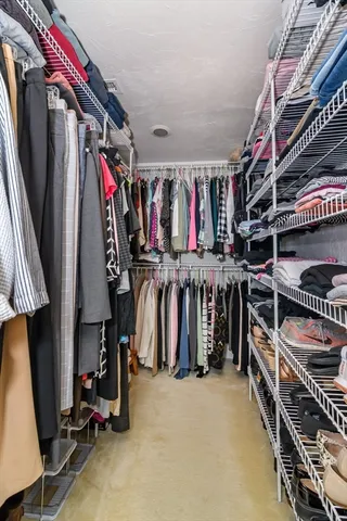 a view of walk in closet with clothes and shoes