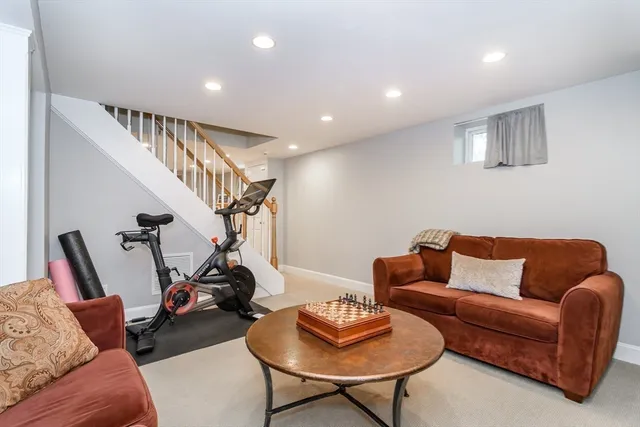 a living room with furniture a rug and white walls