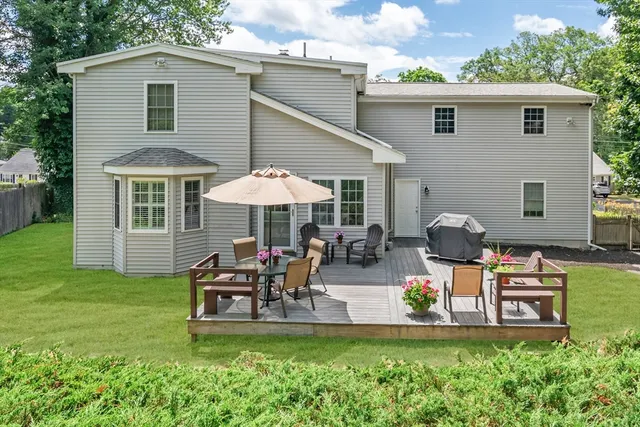 a view of a house with backyard and sitting area