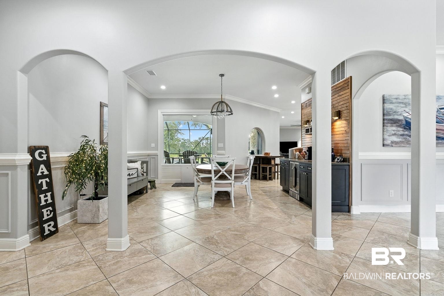 23357 Carnoustie Drive Foley, AL 36535 - Photo 11 of 99 Dining room featuring a decorative wall, wainscoting, a chandelier, ornamental molding, and light tile patterned flooring