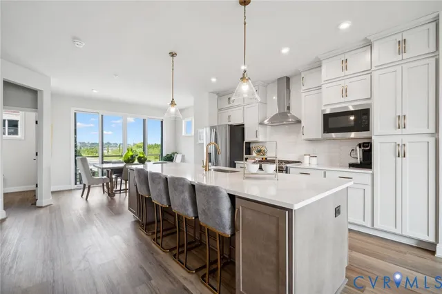 a kitchen with stainless steel appliances a stove a sink a refrigerator and a cabinets