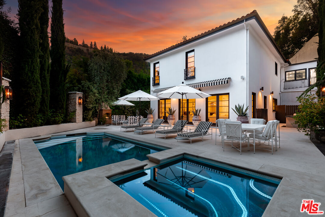 a view of a house with pool and chairs