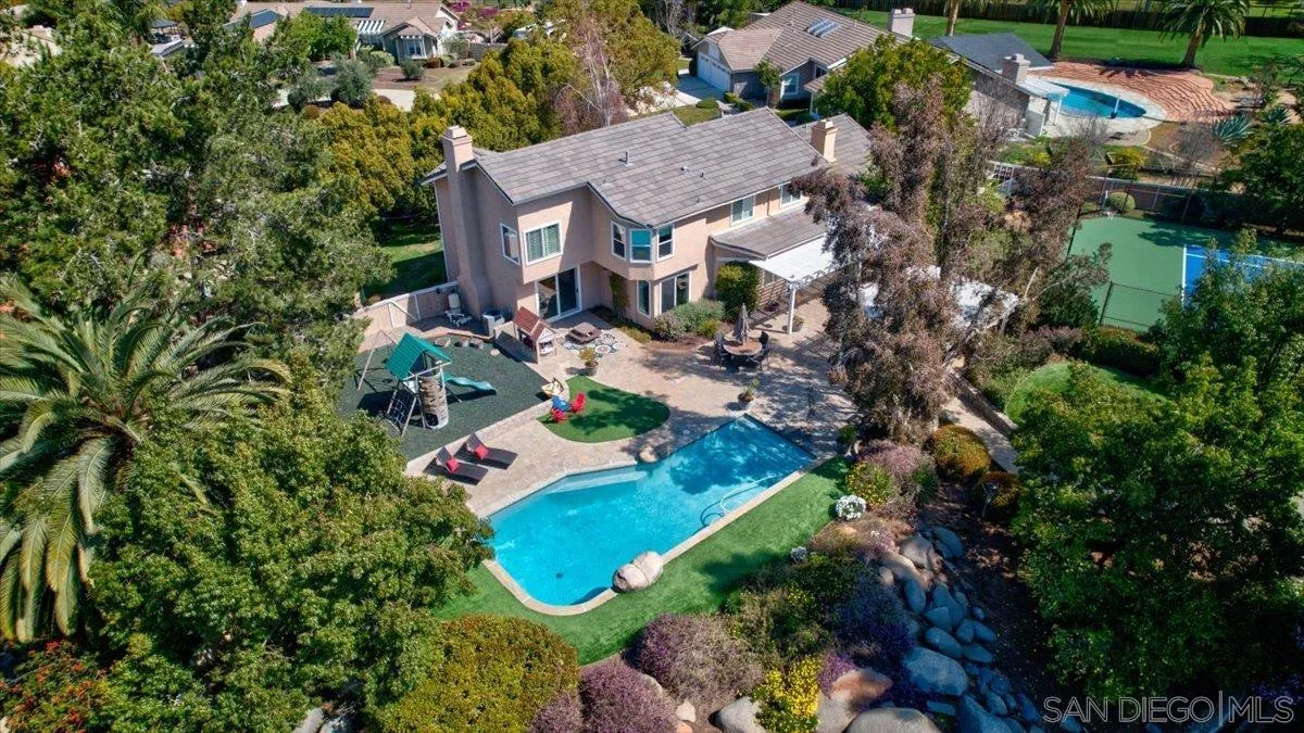 an aerial view of a house with a yard and lake view