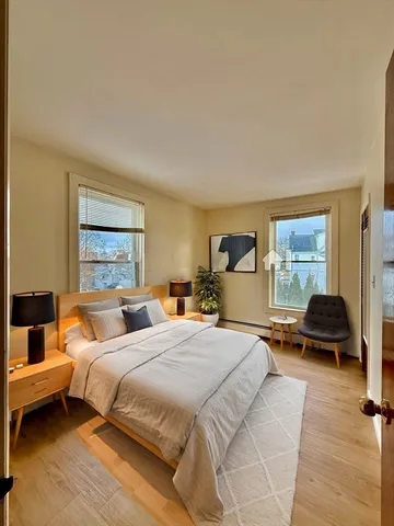 a spacious bedroom with wooden floor