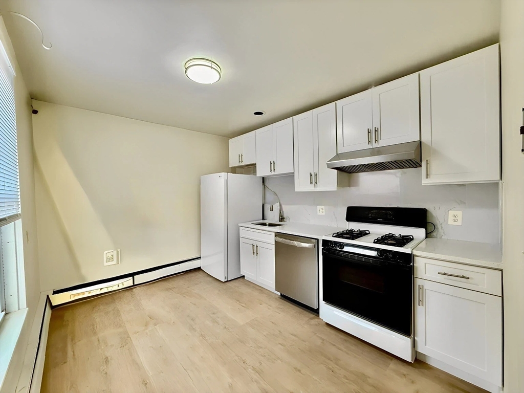 17 Maple Street, Unit 2 Braintree, MA 02184 - Photo 6 of 25 a kitchen with stainless steel appliances granite countertop a stove a refrigerator and white cabinets