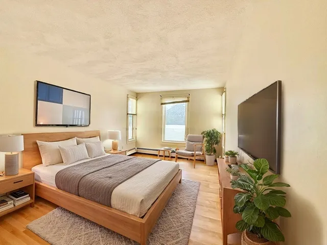 a spacious bedroom with a bed and a painting on the wall