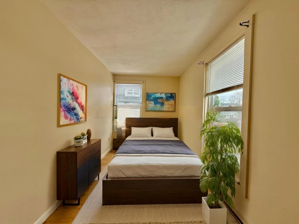 17 Maple Street, Unit 2 Braintree, MA 02184 - Photo 10 of 25 a spacious bedroom with a bed and a painting on the wall