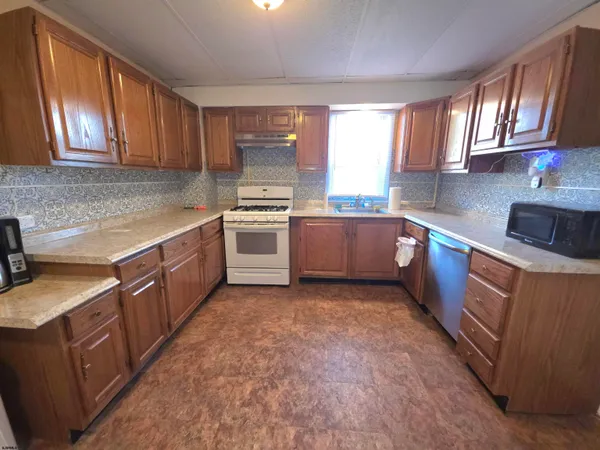 a kitchen with stainless steel appliances granite countertop a sink stove and cabinets