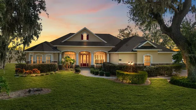 a front view of a house with a garden and trees