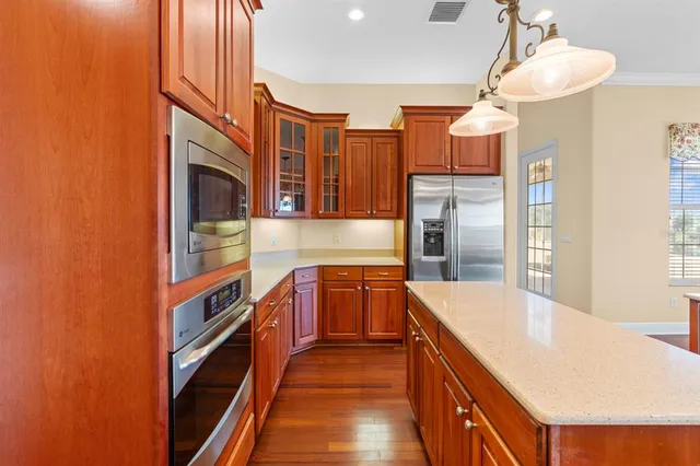 a kitchen with stainless steel appliances granite countertop a sink and a refrigerator