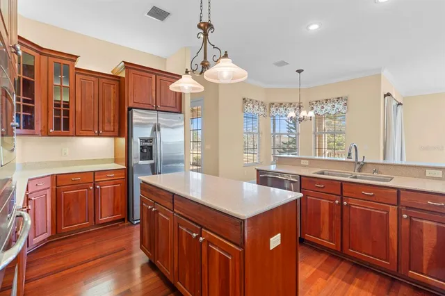a large kitchen with stainless steel appliances a sink and a large window
