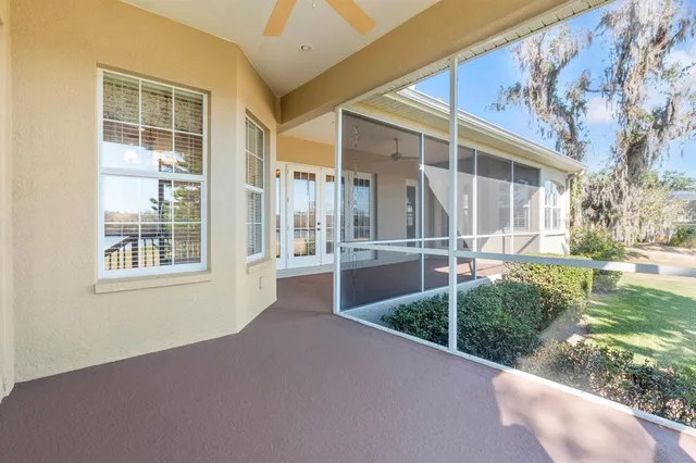 a front view of a house with swimming pool and large trees
