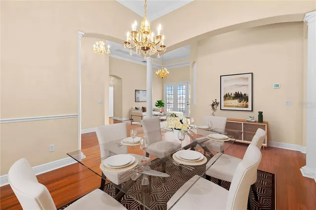 a living room with furniture a chandelier and a dining table
