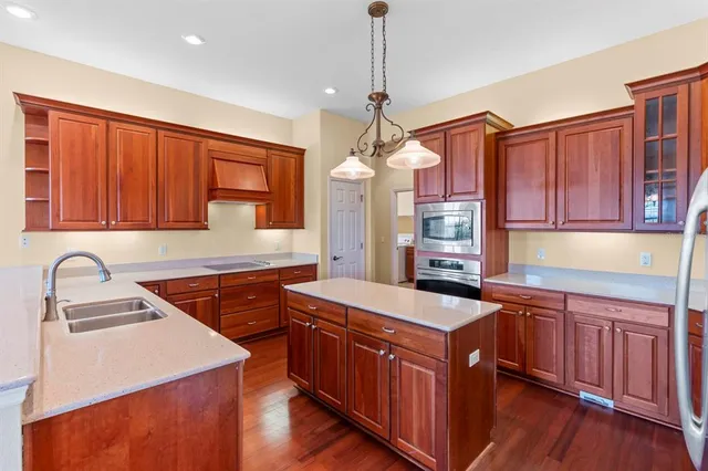 a kitchen with stainless steel appliances granite countertop a sink stove and cabinets