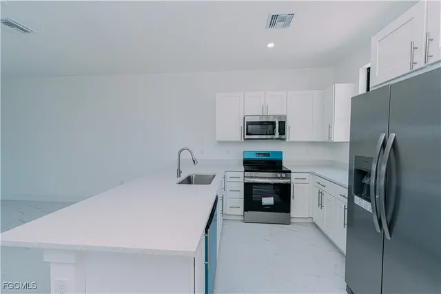 a kitchen with stainless steel appliances a refrigerator sink and stove