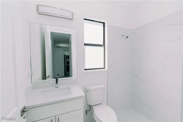 a bathroom with a toilet sink and mirror