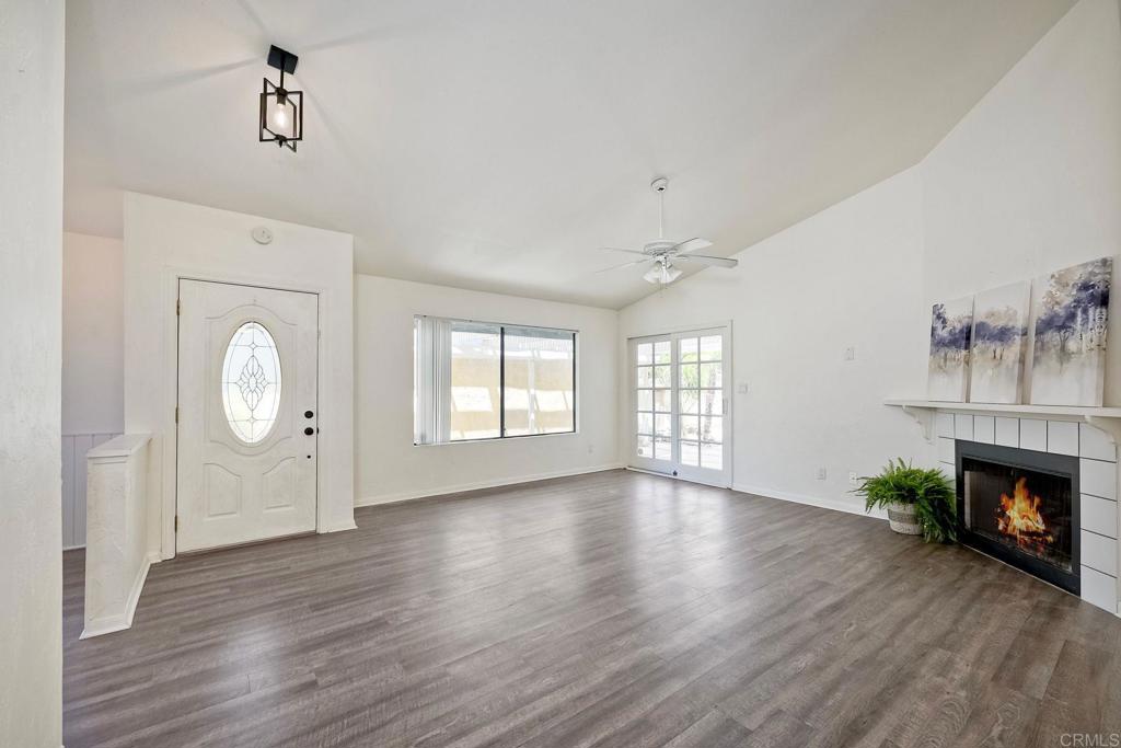 2131 Teal Glen Escondido, CA 92026 - Photo 11 of 35 an empty room with wooden floor a fireplace and windows