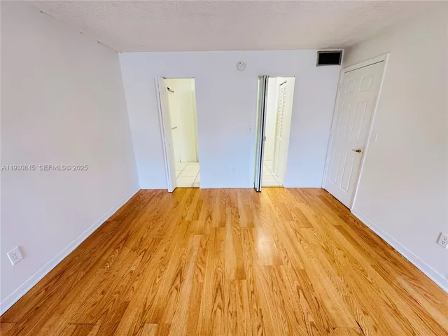 a view of room with wooden floor and windows