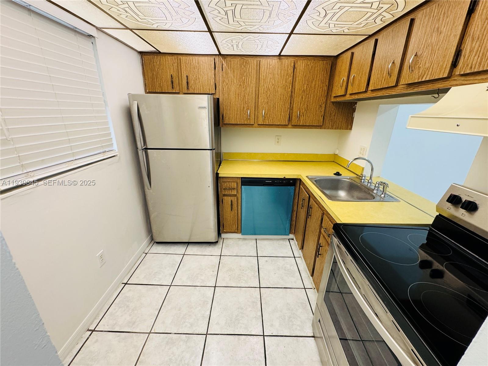 2800 Northwest 56th Avenue, Unit D102 Lauderhill, FL 33313 - Photo 8 of 25 a kitchen with a refrigerator a stove top oven and a sink
