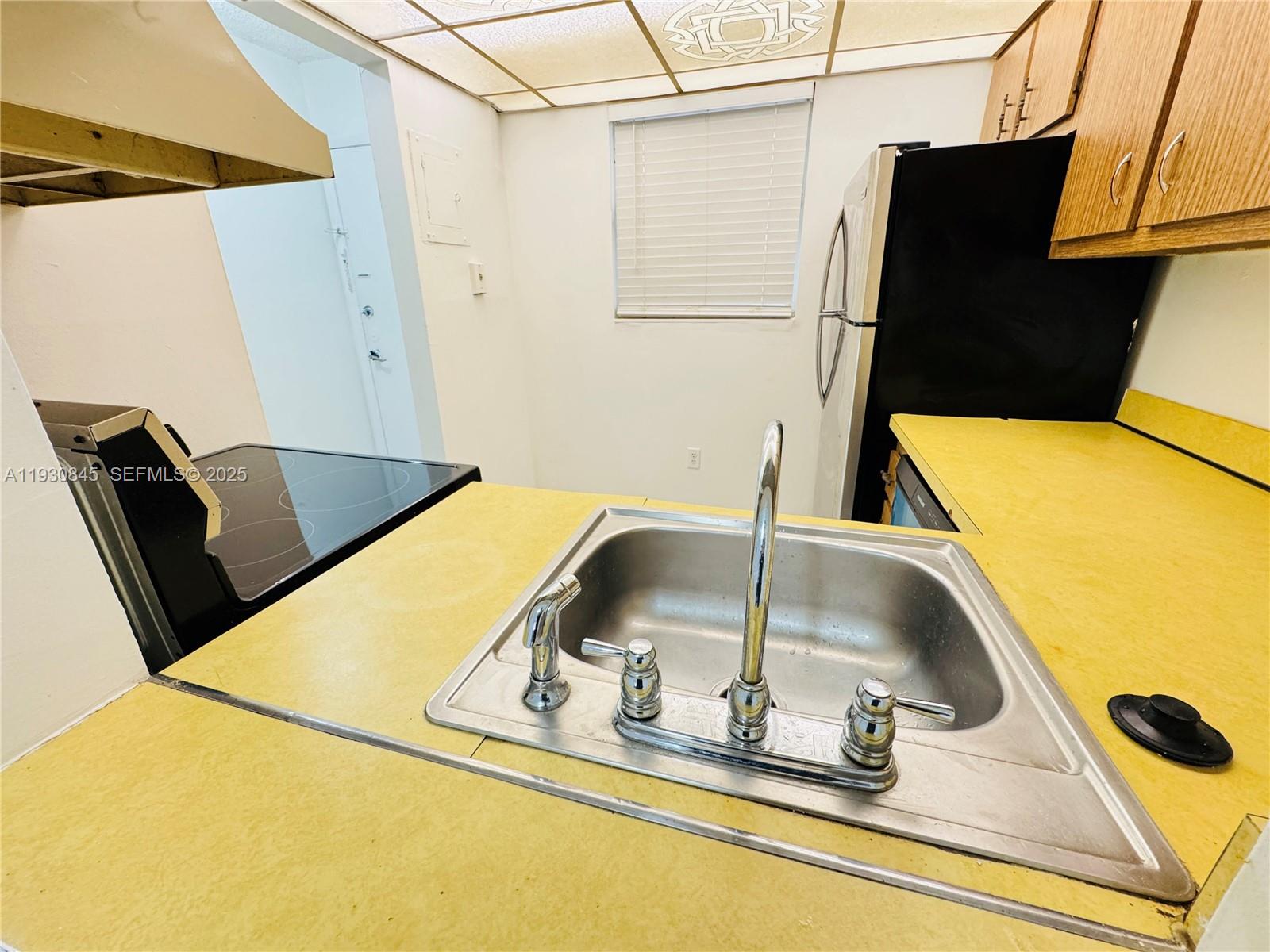 2800 Northwest 56th Avenue, Unit D102 Lauderhill, FL 33313 - Photo 9 of 25 a kitchen with a sink and a refrigerator