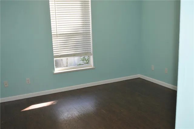 a view of a room with wooden floor and a window
