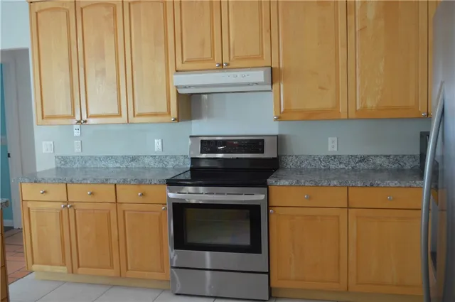 a kitchen with granite countertop cabinets stainless steel appliances and a sink