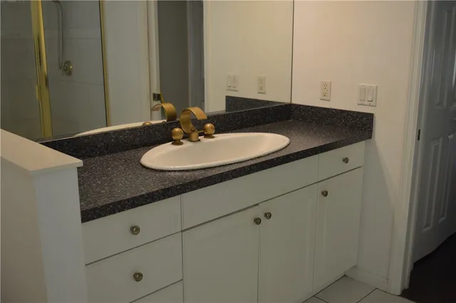 a bathroom with a granite countertop sink and a mirror