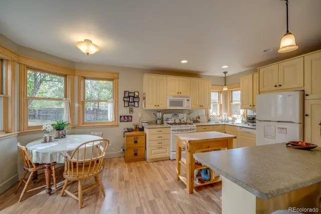 a kitchen with a table chairs stove and cabinets
