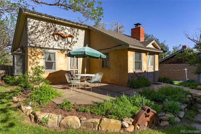 a view of a house with backyard and sitting area