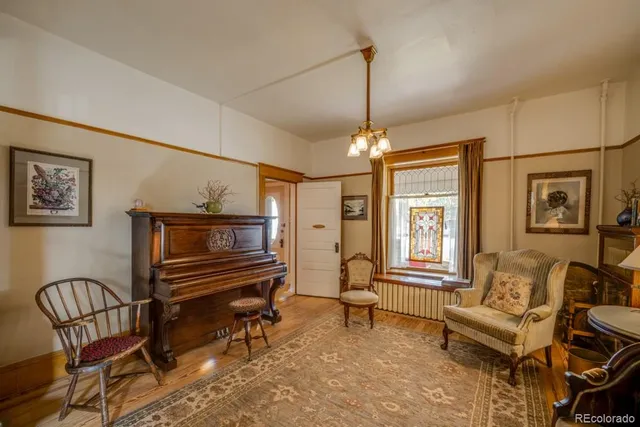 a living room with furniture a piano and a chandelier