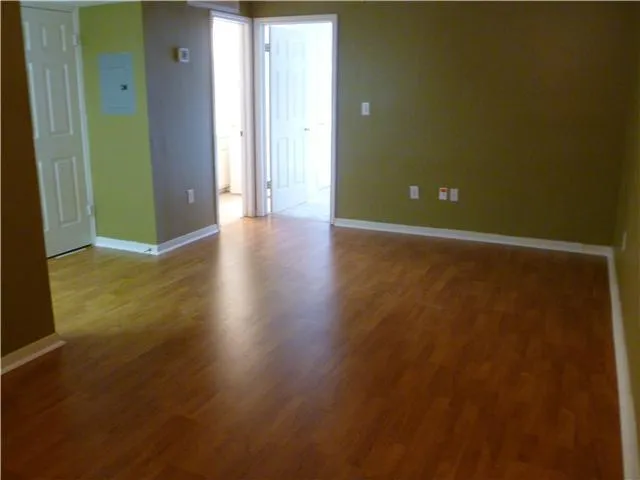 an empty room with closet and windows