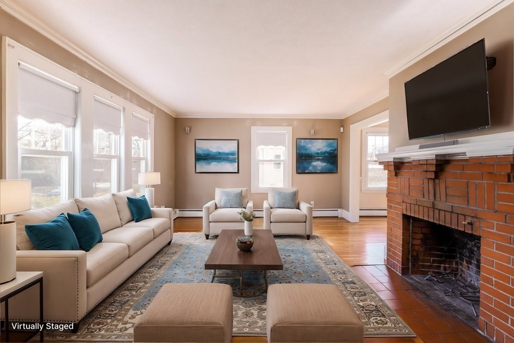 8 Smith Avenue Reading, MA 01867 - Photo 16 of 32 a living room with furniture a flat screen tv and a fireplace