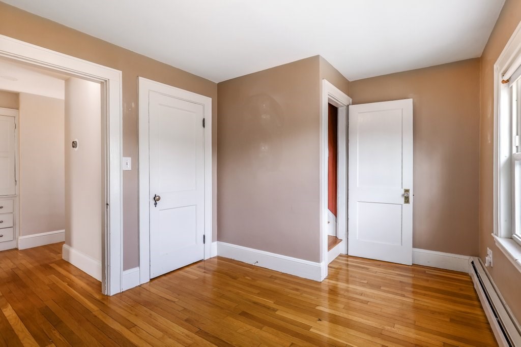 8 Smith Avenue Reading, MA 01867 - Photo 24 of 32 a view of an empty room with wooden floor and a window