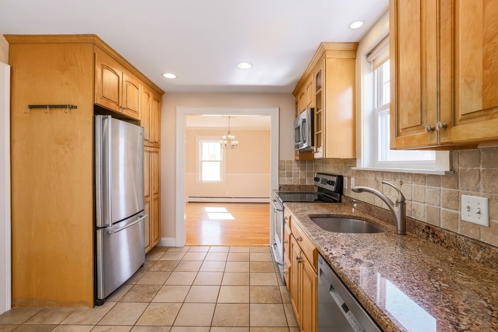 8 Smith Avenue Reading, MA 01867 - Photo 8 of 32 a kitchen with granite countertop a refrigerator a sink and dishwasher