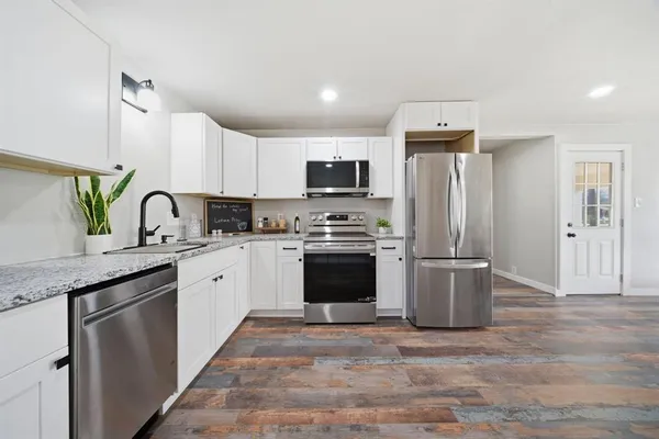 a kitchen with granite countertop a refrigerator and a sink