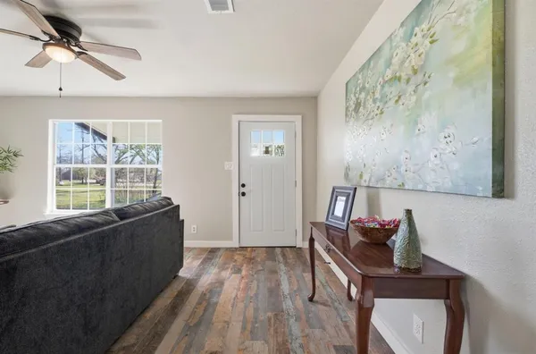 a living room with furniture and a wooden floor